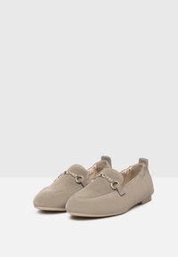 Beige Wildleder Slipper mit runder Zehenform, dekorativer metallischer Kettenakzent und flachem, niedrigem Absatz. Weiches Futter und minimalistisches Design.
