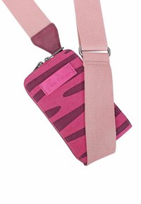 Bustina in tessuto a righe rosa con cerniera, attaccata a una larga tracolla rosa. Accento in pelle marrone alla connessione della tracolla.