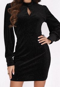 Czarna aksamitna sukienka z długimi rękawami, wysokim kołnierzem i detalem w kształcie keyhole. Posiada subtelny wzór diamentowy i dopasowany krój.