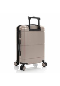 Valigia rigida con un esterno metallico color oro rosa, design elegante, manico telescopico e quattro ruote duali per la mobilità.