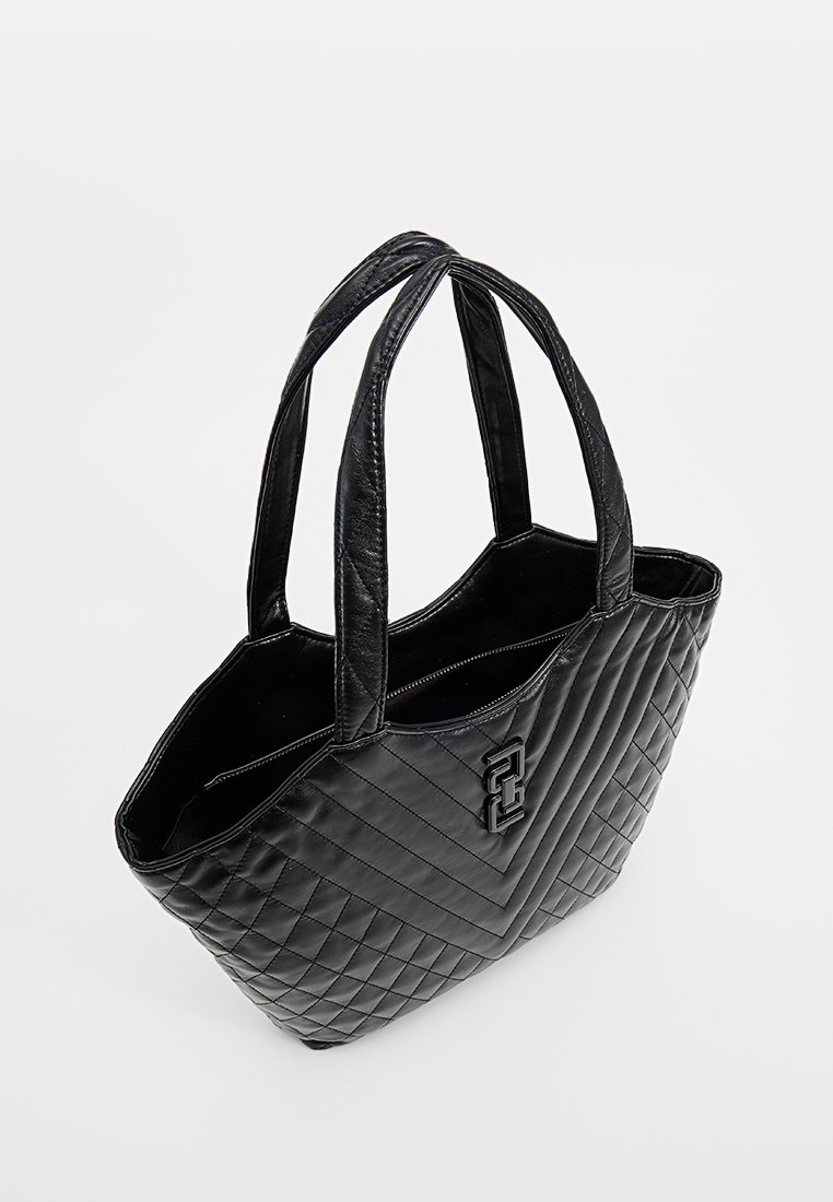 Sac fourre-tout noir matelassé avec deux poignées, présentant une texture en cuir lisse et un accent de logo bien visible sur le devant.