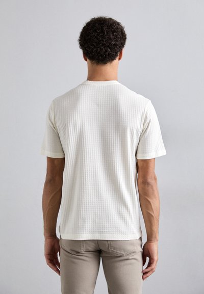 Kortærmet t-shirt med rund hals i struktureret off-white bomuld. Har en subtil rutenetstruktur og kontrasterende kantbånd på ærmerne.