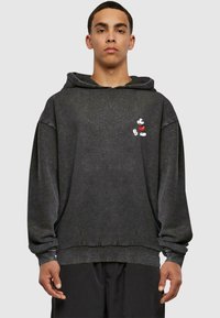 Schwarzer Hoodie aus weichem Stoff mit lässiger Passform, ausgestattet mit einem kleinen weißen Mickey-Maus-Grafik auf der Brust. Mit Kordelzug-Haube.
