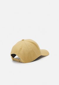 Gorra de béisbol color caqui hecha de tela suave, con una visera curva, correa ajustable en la parte trasera y orificios de ventilación.