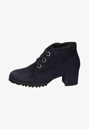 Bottine en daim bleu marine à talon épais, fermeture à lacets à l’avant avec trois œillets métalliques, semelle en caoutchouc noire à nervures.