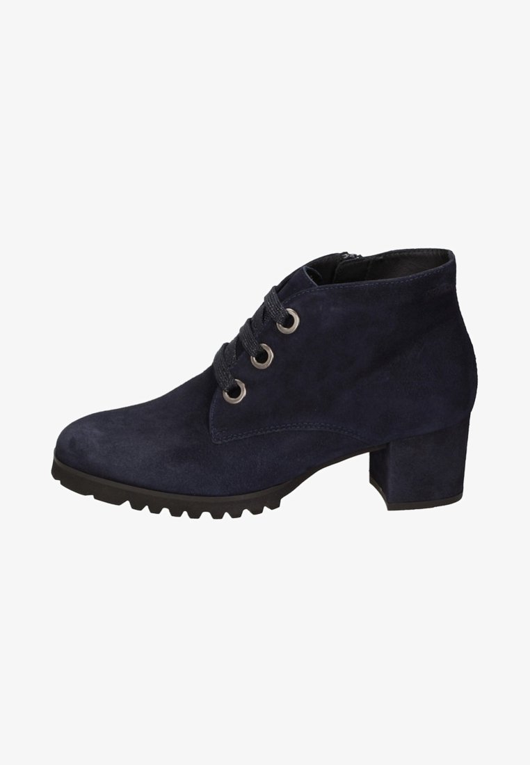 Bottine en daim bleu marine à talon épais, fermeture à lacets à l’avant avec trois œillets métalliques, semelle en caoutchouc noire à nervures.