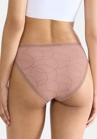 Hoge taille roze onderbroek met een gladde textuur, voorzien van cirkelpatronen en een decoratieve kanten rand langs de tailleband.
