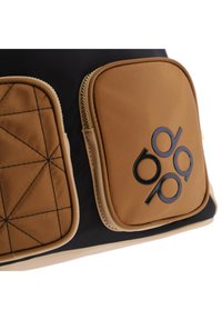 Bolso negro y marrón con dos bolsillos frontales con cremallera, que presenta un patrón geométrico cosido y un acento de logo en el bolsillo derecho.