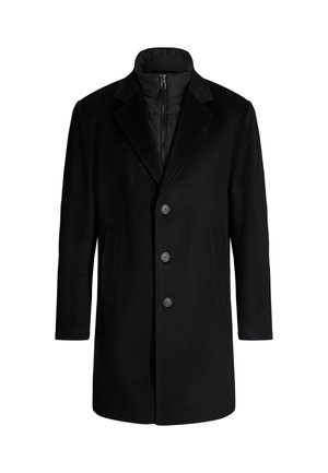 Czarny płaszcz o dopasowanym kroju, z zapięciem na guziki, klapami i bocznymi kieszeniami. Materiał zewnętrzny jest gładki, a podszewka jest pikowana.