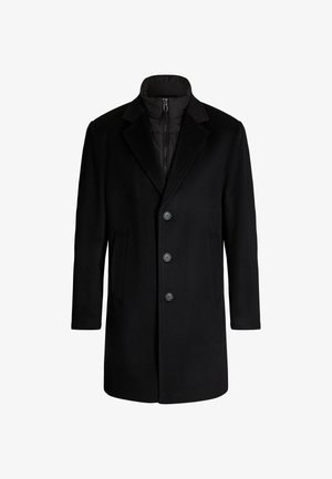 Zwarte jas met een op maat gemaakte ontwerp, voorzien van een knoopsluiting aan de voorkant, notch-revers en zijzakken. Buitenmateriaal is glad, de binnenvoering is doorgestikt.