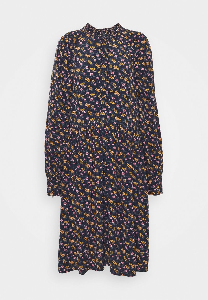 Šaty s květinovým potiskem v námořnické modři, s dlouhými rukávy, vysokým výstřihem a splývavým střihem, na kterém jsou rozmístěny malé růžové a žluté květy.