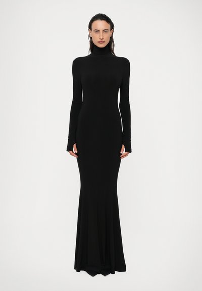 Abito lungo nero con maniche lunghe e collo alto. Silhouette aderente che si apre in un orlo a forma svasata. Tessuto liscio e elasticizzato con aperture per i pollici alle maniche.