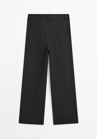 Schwarze, weit geschnittene Hose aus strukturiertem Stoff mit einem dezenten Nadelstreifenmuster. Auf der Rückseite befindet sich eine einzelne Paspeltasche.