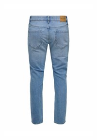 Jeans de mezclilla azul claro con un diseño de pierna recta, que cuentan con bolsillos traseros y una etiqueta de cuero marrón en la cintura.