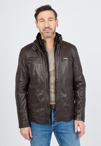 Bruine leren jas met een hoge kraag, ritssluiting aan de voorkant en twee borstzakken. Heeft een gladde textuur en een slim fit ontwerp.