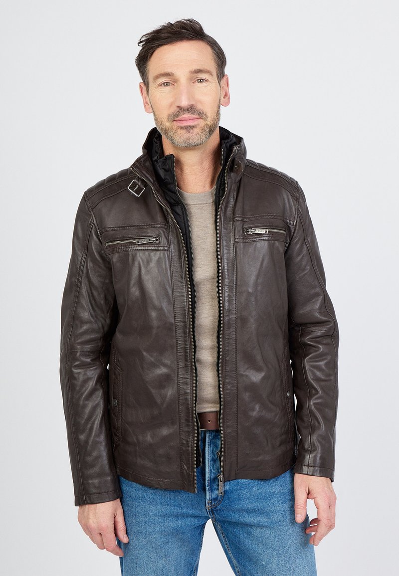 Bruine leren jas met een hoge kraag, ritssluiting aan de voorkant en twee borstzakken. Heeft een gladde textuur en een slim fit ontwerp.