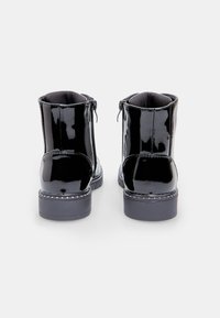 Botine din piele patent neagră, cu finisaj neted, închidere cu fermoar pe lateral și vârf rotund. Incluzând o talpă cusută în contrast.