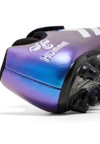 Une chaussure de football métallique violette et bleue avec une texture douce, dotée de crampons noirs et du logo "hummel" sur le côté.