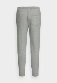 Pantaloni da tuta grigi realizzati in un tessuto morbido, dotati di un elastico in vita e di una tasca posteriore, design a gamba affusolata con polsini a costine.