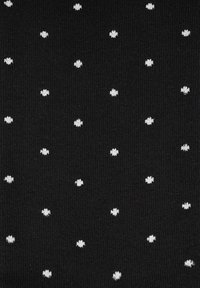 Czarna tkanina z regularnym wzorem małych białych kropek. Tekstura przypomina dzianinę, zapewniając miękką i elastyczną powierzchnię.