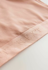 Helles rosa Gewebe mit einer glatten Textur, versehen mit einem genähten Streifen, der am Rand das Wort "NEXT" geprägt hat. Einfaches, minimalistisches Design.