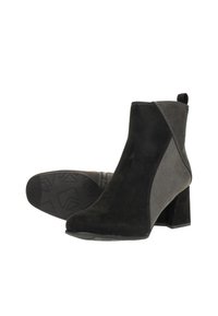 Bottines en suède noir avec un talon bloc, présentant un panneau gris contrastant, une texture lisse et une coupe à la cheville courte.