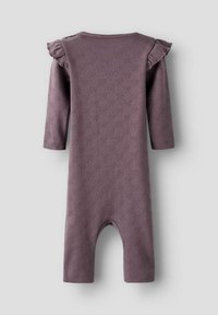 Lila långärmad bodysuit med volangdetaljer på axlarna, med ett strukturerat mönster av små trianglar överallt. Hel långa ben.