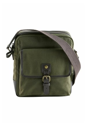 Olivgrüne Canvas-Umhängetasche mit einem braunen Riemen und Lederakzenten. Verfügt über eine Fronttasche mit Druckknopfverschluss und einem verstellbaren Riemen.