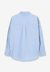 Light blue long-sleeve shirt featuring a pointed collar, pleat detail at the back, and button accents on the cuffs. Smooth fabric texture.