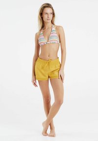 Bikini met meerkleurige strepen en een driehoekig ontwerp, gecombineerd met gele shorts met een trekkoord en kantafwerking.