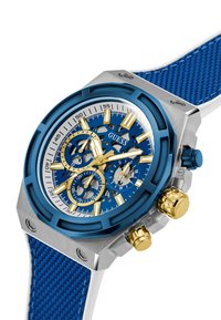 Blaue Chronographuhr mit Edelstahlgehäuse, strukturiertem blauen Armband, goldenen Akzenten und einem detailreichen Skelettzifferblatt mit weißen Markierungen.
