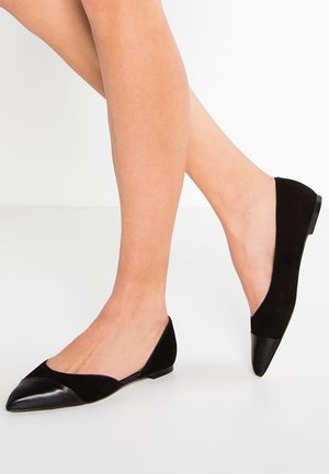 Black suede flats with a pointed toe design, featuring a glossy leather cap at the toe and a low heel for comfort.