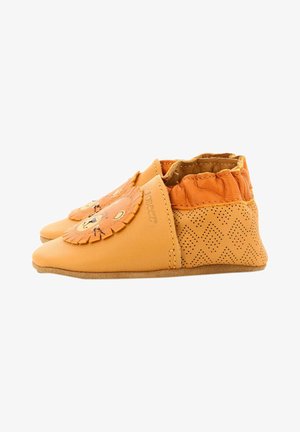 Chaussures en cuir orange avec un motif de visage de lion, des détails en franges et des accents perforés sur les côtés. Semelle plate et douce.