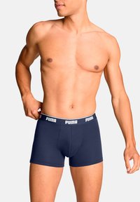 Boxers de algodón azul marino con una amplia cintura elástica blanca con la marca "PUMA". Diseño ajustado con una textura suave.