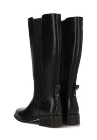 Botas de cuero negro hasta la rodilla con paneles laterales elásticos, una textura suave y un pequeño acento decorativo de metal en el talón trasero.