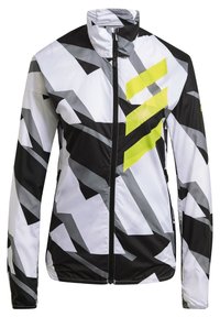 Vindjakke med et geometrisk mønster i sort, hvid og grå med en lys gul accent. Letvægtsstof med ståkrave.