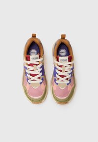 Multicolored sneakers with mixed materials, featuring pink, green, purple, and beige accents, white laces, and a textured sole.