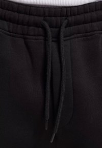 Schwarze Baumwoll-Sweatpants mit einem elastischen Taillenbund und Kordelzug, einer glatten Textur und seitlichen Taschen.