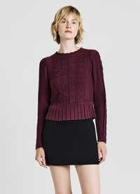Maglione a maglia bordeaux con orlo a costine, motivi testurizzati e maniche lunghe, abbinato a una mini gonna nera.