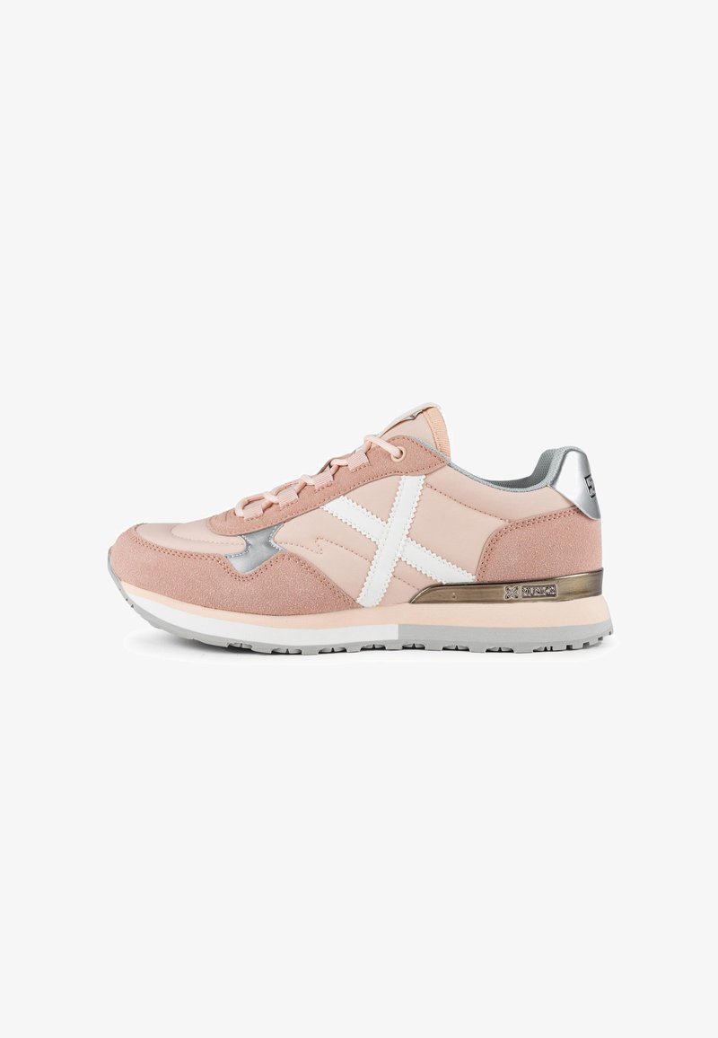 Scarpa sportiva rosa chiaro in materiali scamosciati e in rete, con accento bianco incrociato, tallone argentato e suola in gomma testurizzata.