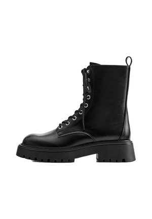 Botte de combat noire en cuir à lacets avec semelle en caoutchouc épaisse et languette à l’arrière, vue de côté sur fond blanc.