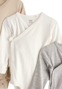 Drei Wickelbodys für Säuglinge in Beige, Weiß und Grau. Hergestellt aus weicher Baumwolle, mit einem Wickeldesign, Druckknopfverschlüssen und langen Ärmeln.