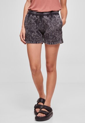 Black, textured, short sweat shorts with an elastic waistband and side pockets, paired with black slide sandals.
