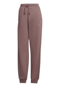 Spodnie dresowe Adidas w kolorze zakurzonego różu, wykonane z miękkiej tkaniny. Posiadają elastyczny pas z sznurkiem i boczne kieszenie. Rękawy wykończone są mankietami.