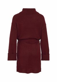 Robe pull en tricot bordeaux avec un col haut, des manches larges et une ceinture à la taille ; texture douce et coupe décontractée.