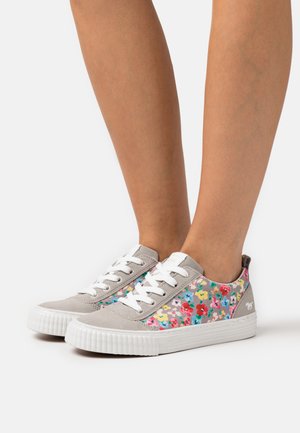 Baskets en suède gris avec un motif floral comprenant des fleurs roses, rouges et bleues sur les côtés ; semelle en caoutchouc blanche et lacets.