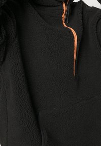 Pullover in pile nero con colletto alto e chiusura a mezza zip, dotato di una zip arancione. Tessuto morbido e testurizzato con tasca frontale.