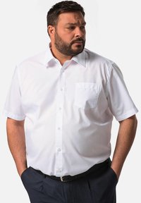 Camisa blanca de manga corta con cuello abotonado y bolsillo en el lado izquierdo del pecho, con una textura suave y un ajuste clásico.
