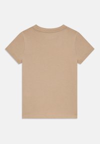 Brown cotton T-shirt with short sleeves and a round neckline. Smooth texture, simple design, and no visible logos or patterns.