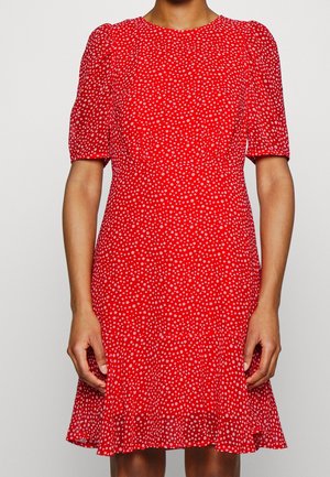 Červené šaty s krátkými nafouknutými rukávy, vzor puntíků v bílé barvě, přiléhavý živůtek a rozšířená sukně. Lehká látka s hladkou texturou.